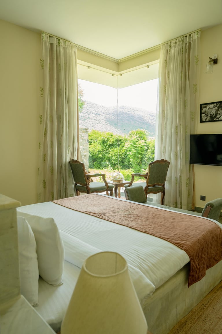 Stone Villa corner window framing the Aravallis